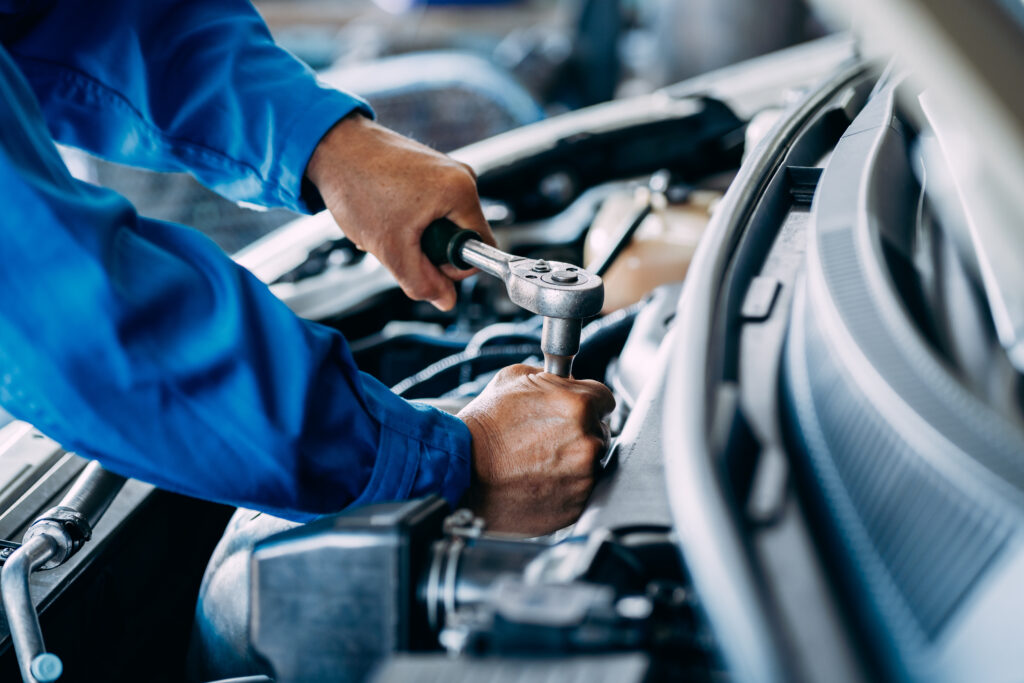 Close up of view Auto mechanic repairman using a socket wrench working engine repair in the garage, change spare part, check the mileage of the car, checking and maintenance service concept.